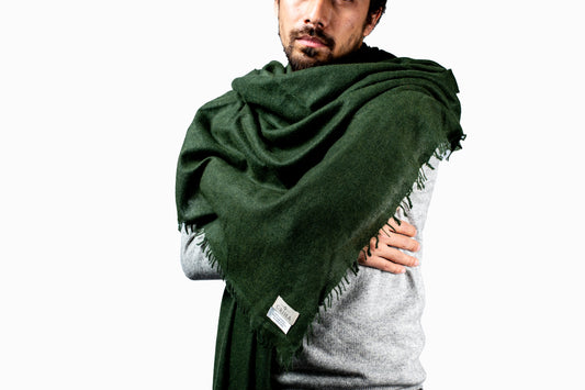 Man wearing a green cashmere scarf over a gray jumper on a white background- GRIHA