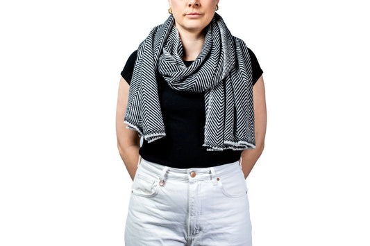 Person wearing a black and white patterned pashmina scarf on a white background- GRIHA