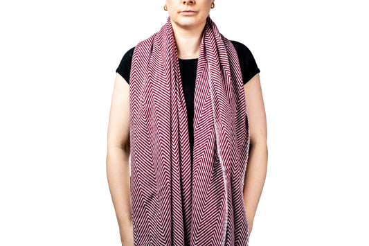 Person wearing a pink and black patterned pashmina scarf on a white background- GRIHA