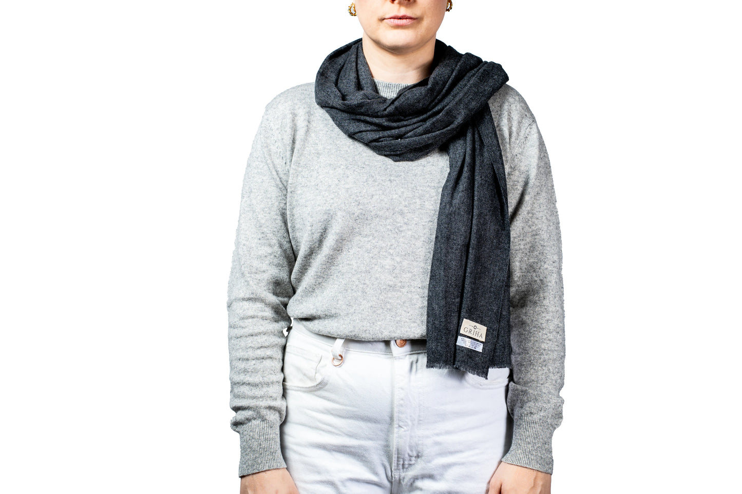 Person wearing a gray sweater and dark scarf on a white background