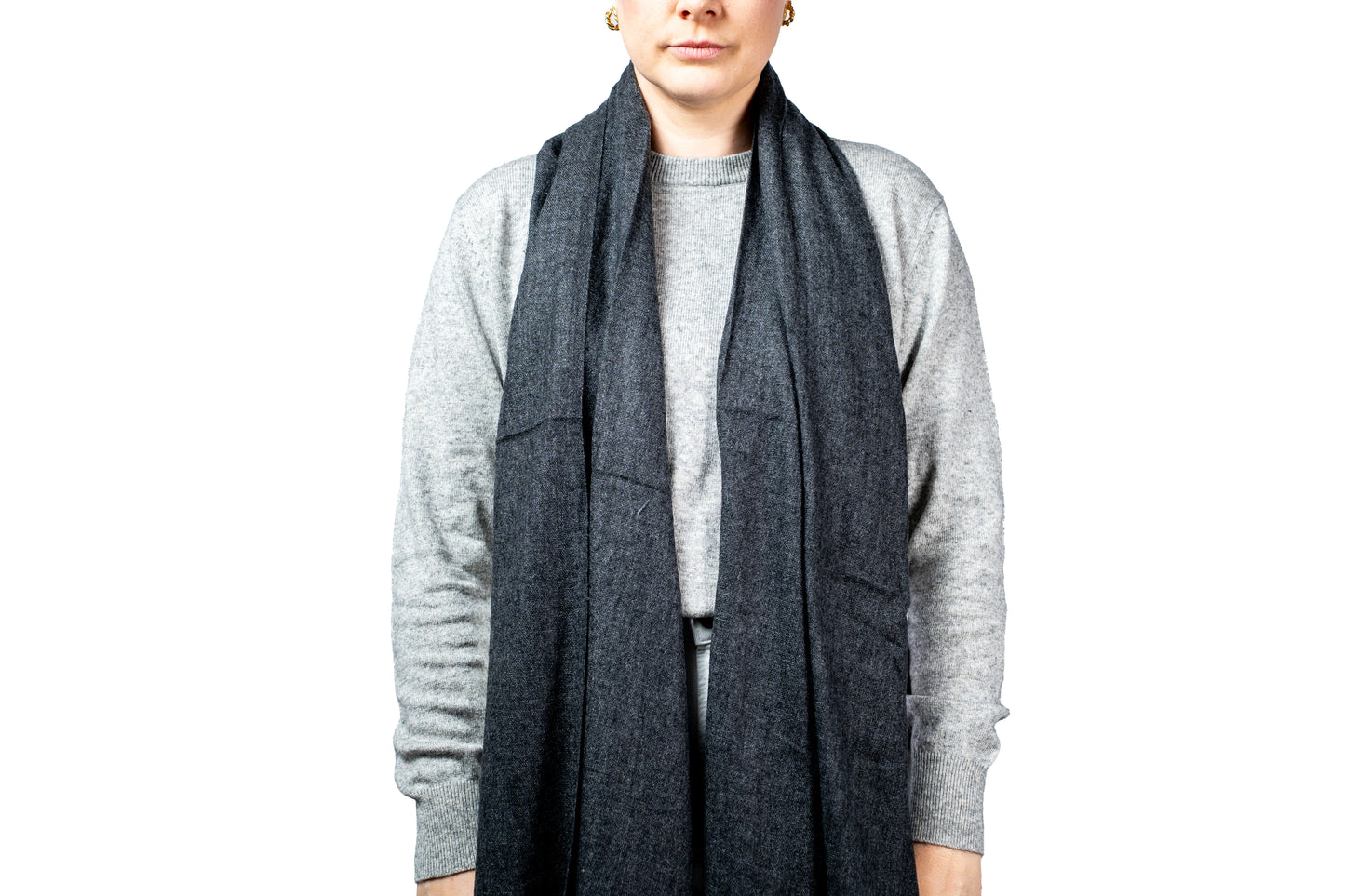 Person wearing a gray cardigan and scarf on a white background