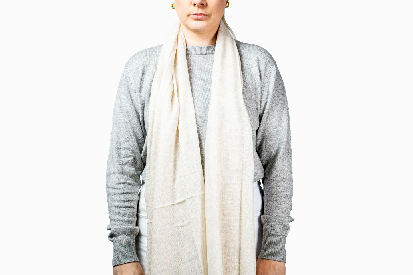 Person wearing a gray sweater and white pashmina scarf on a white background- GRIHA