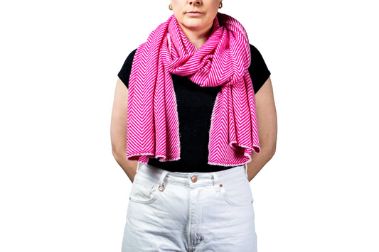 Person wearing a bright pink scarf with a white background