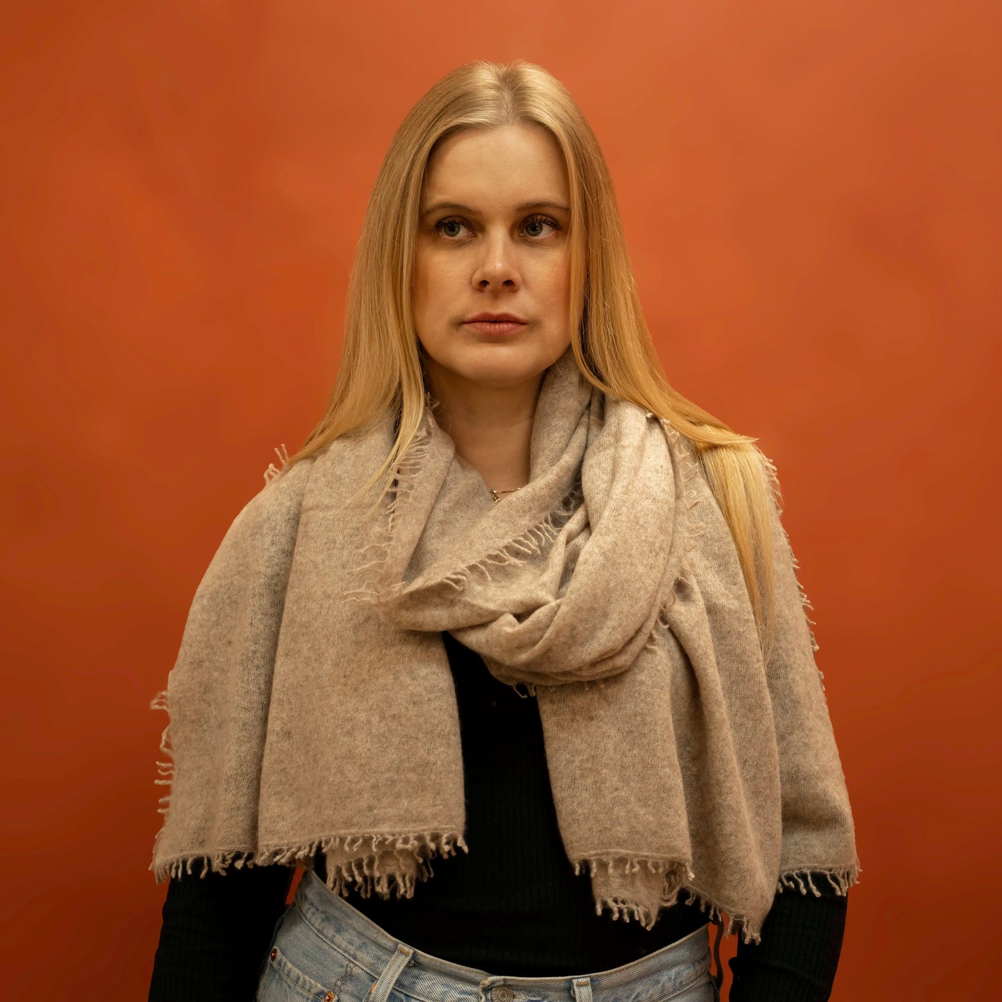 Woman wearing fawn woven cashmere shawl wrapped around neck — handcrafted in Nepal by Griha