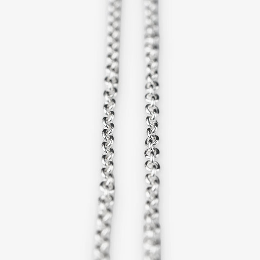 A close-up of a sterling silver belcher chain necklace against a plain white background.