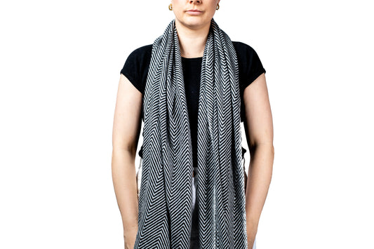 Person wearing a black and white pashmina patterned scarf on a white background- GRIHA