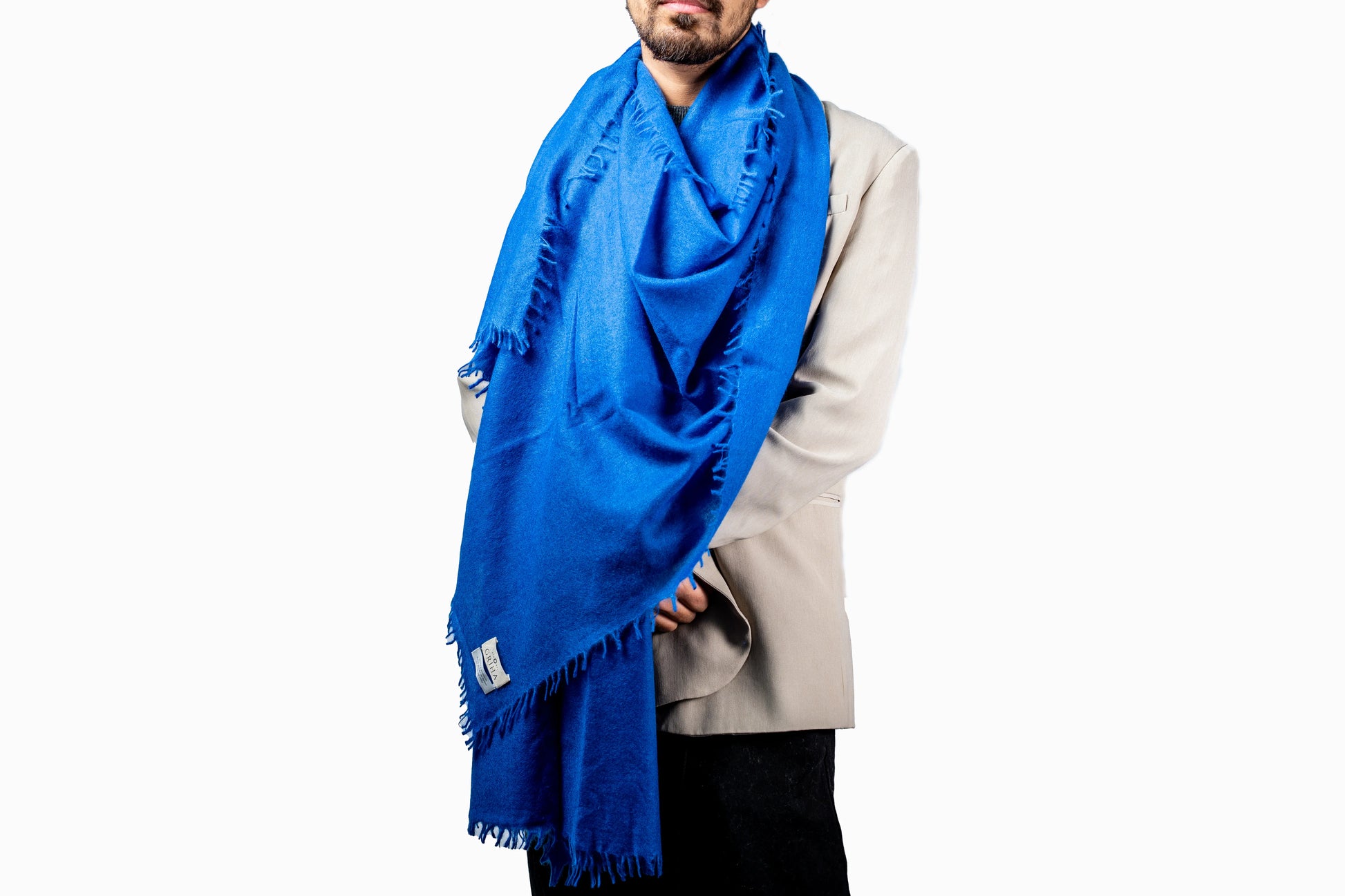 Person wearing a blue cashmere scarf on a white background