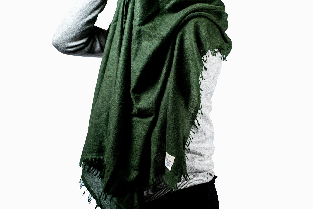 Person wearing a green cashmere scarf on a white background- GRIHA