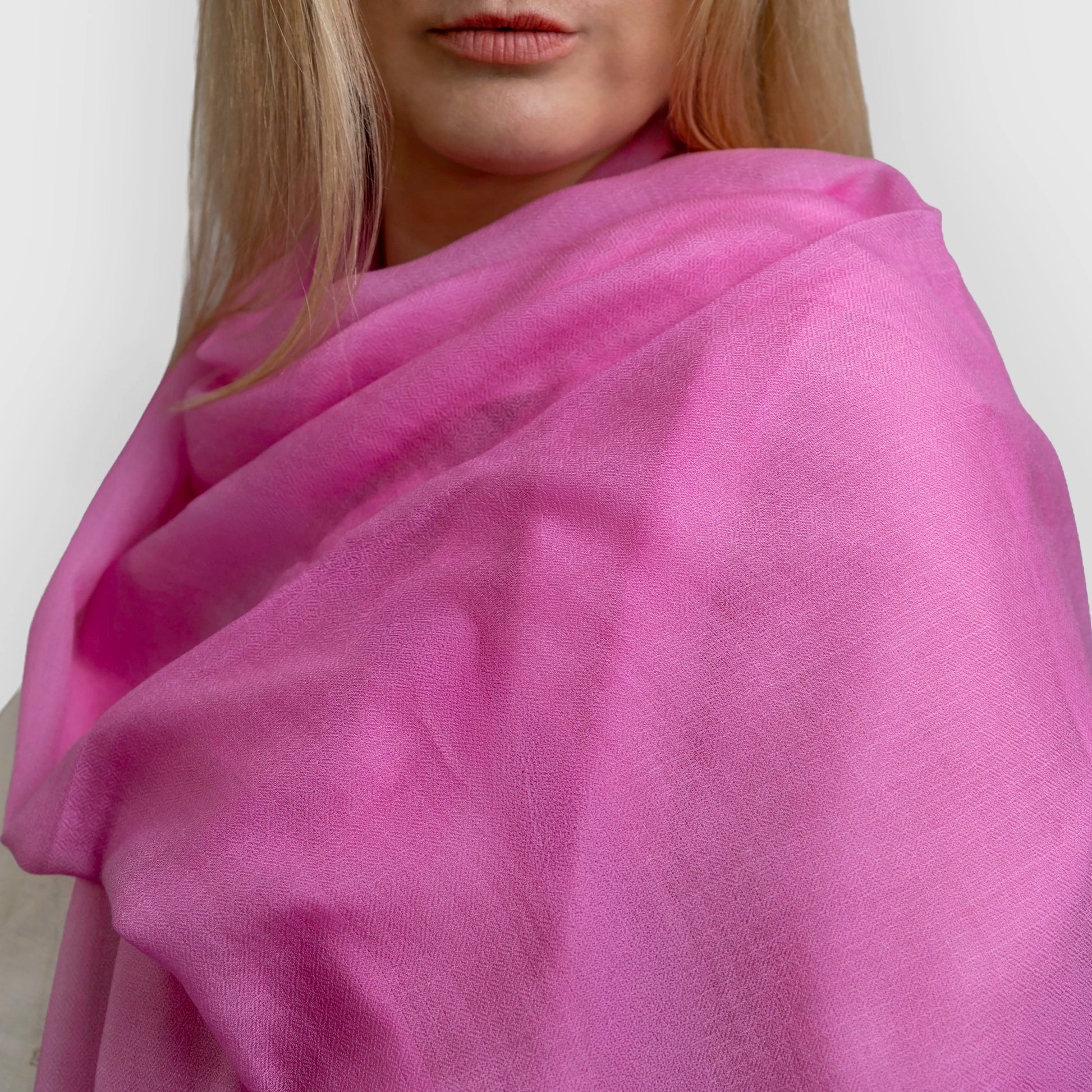 Bright pink pashmina shawl scarf draped over model shoulder 