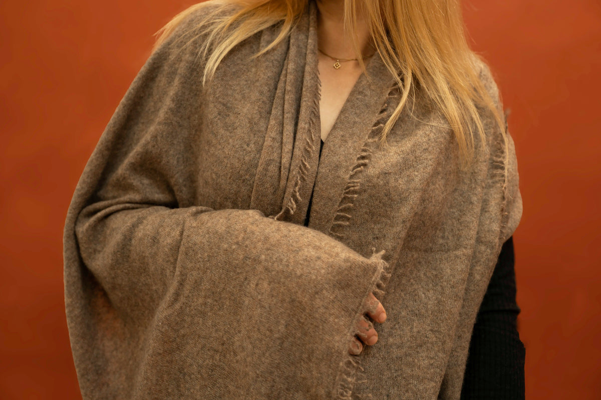 Close-up of taupe brown pure woven cashmere shawl showing open weave texture and fringe trim — Griha Himalayan cashmere