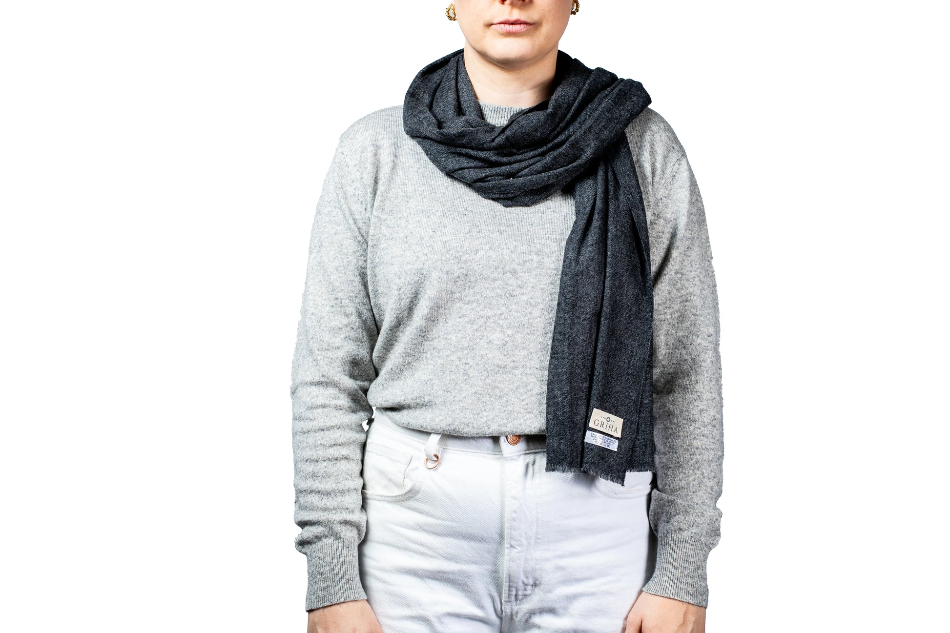 Person wearing a gray sweater and dark scarf on a white background
