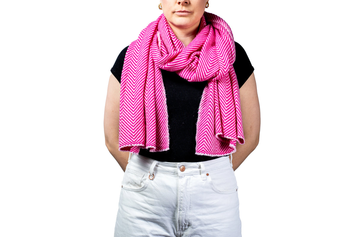 Person wearing a bright pink scarf with a white background