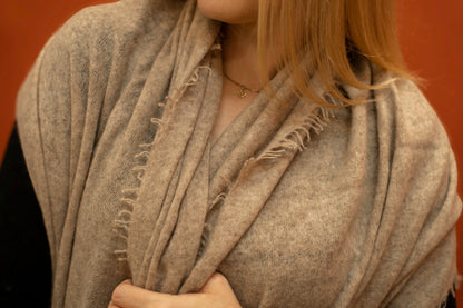 Close-up of fawn pure woven cashmere shawl showing open weave texture and fringe trim — Griha Himalayan cashmere