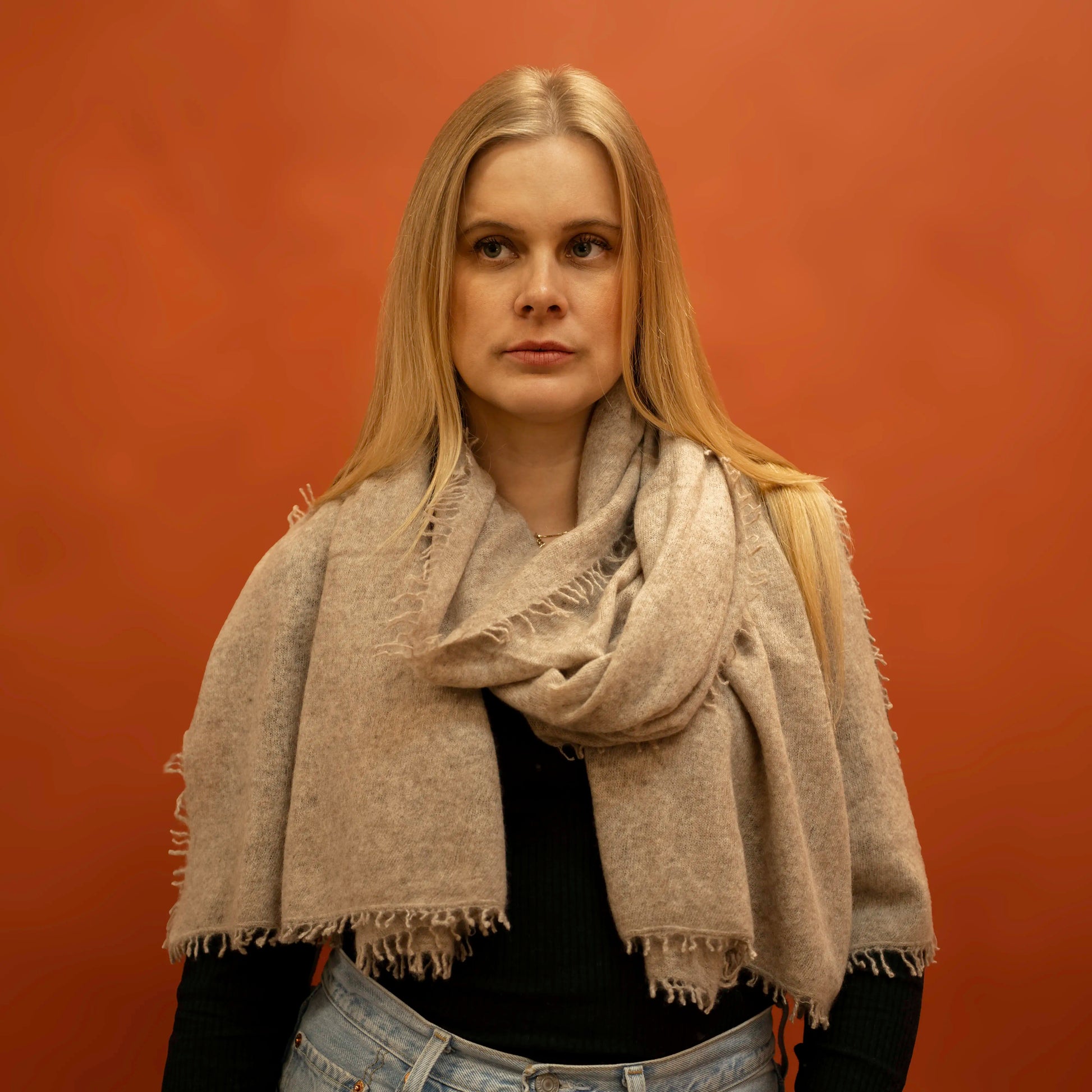 Woman wearing fawn woven cashmere shawl wrapped around neck — handcrafted in Nepal by Griha