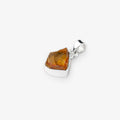 A polished silver pendant featuring a raw, faceted citrine gemstone, shown on a clean light gray background.