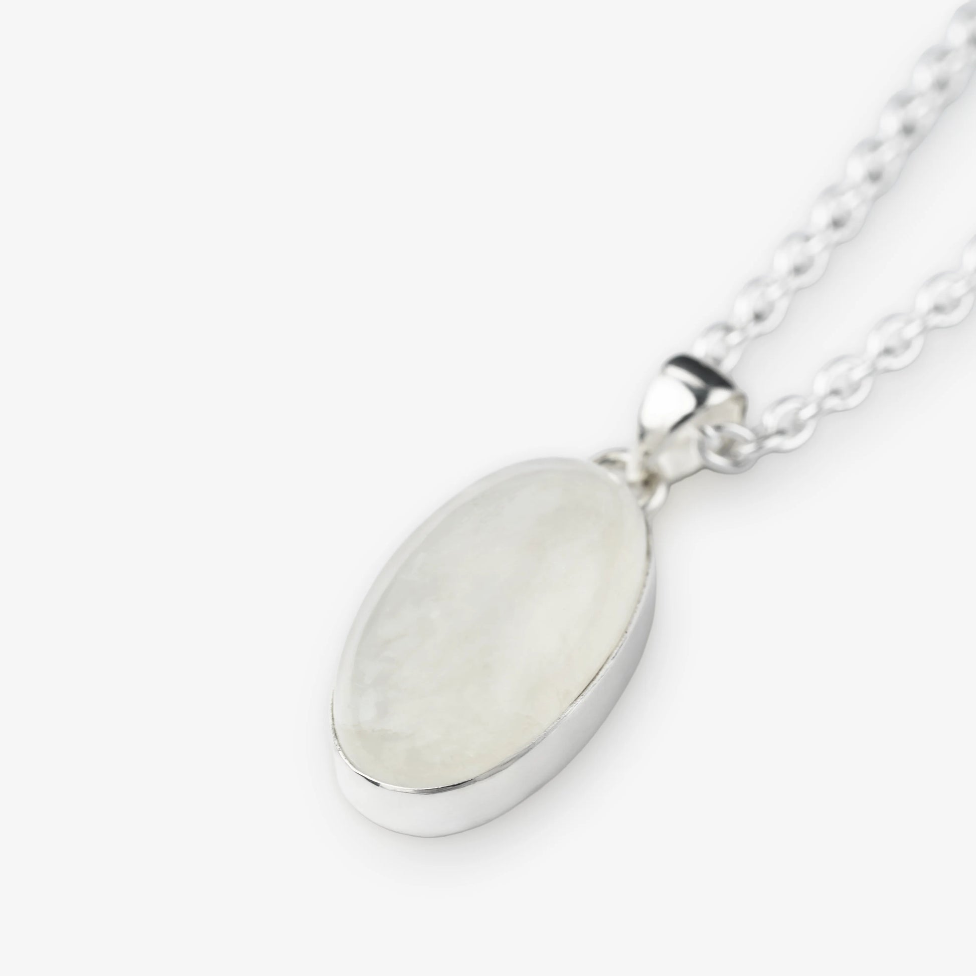 An oval pendant necklace featuring a milky white, iridescent moonstone set in a polished silver bezel, suspended from a silver chain against a light gray background.