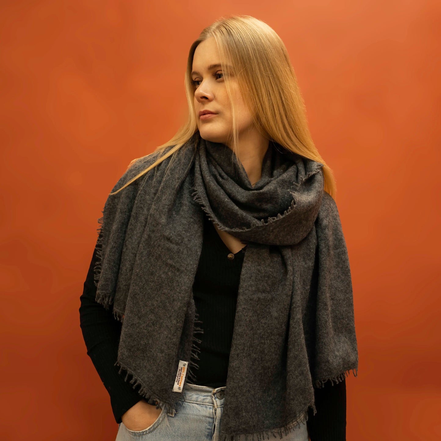 Woman wearing oversized charcoal woven cashmere shawl wrapped around neck — Griha pure Himalayan cashmere