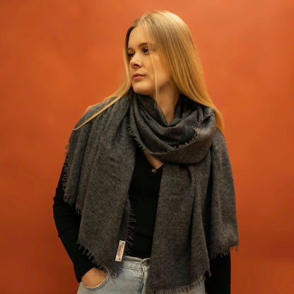 Woman wearing oversized charcoal woven cashmere shawl wrapped around neck — Griha pure Himalayan cashmere