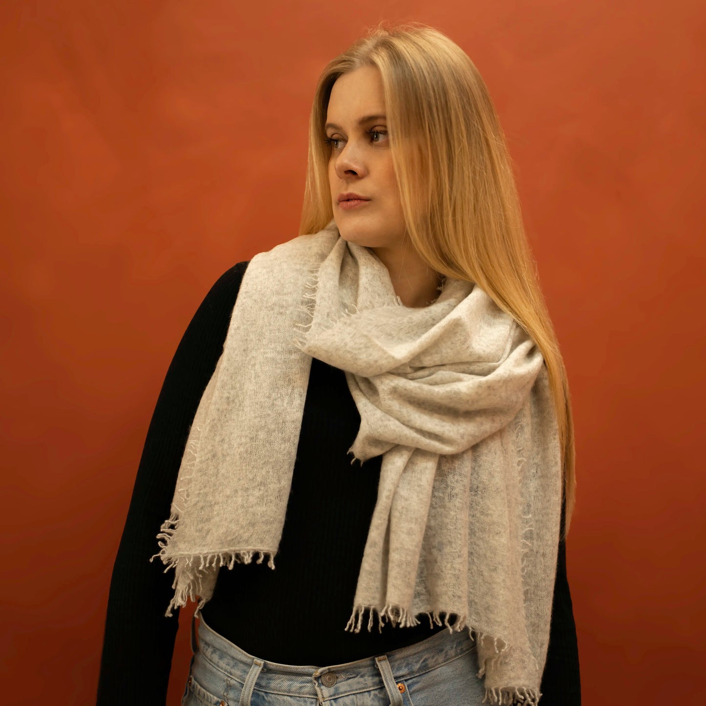 Woman wearing light grey woven cashmere shawl wrapped around neck — handcrafted in Nepal by Griha