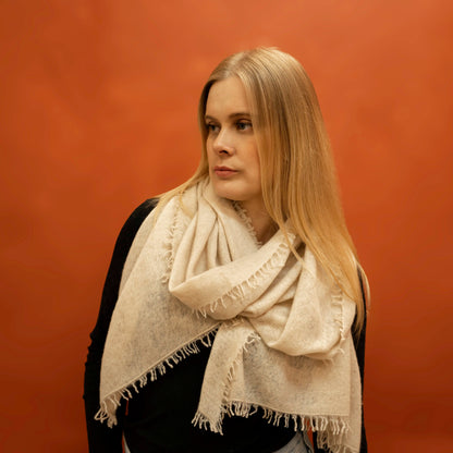 Woman wearing oversized beige woven cashmere shawl wrapped around neck — Griha pure Himalayan cashmere