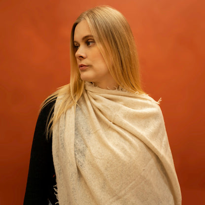Beige woven cashmere shawl draped as shoulder wrap — handcrafted in Nepal by Griha