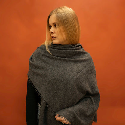 Charcoal woven cashmere shawl draped as shoulder wrap — handcrafted in Nepal by Griha