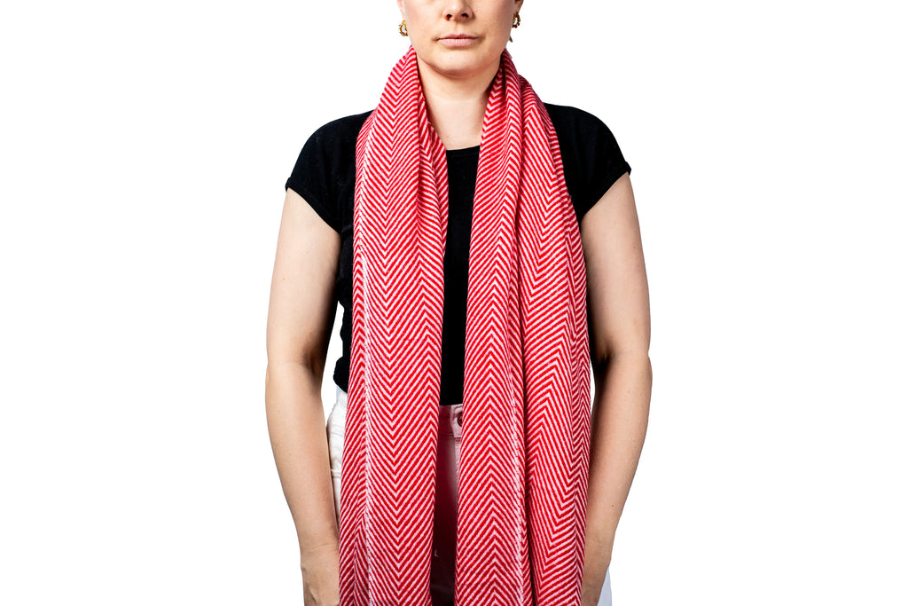 Person wearing a red patterned pashmina scarf on a white background- GRIHA