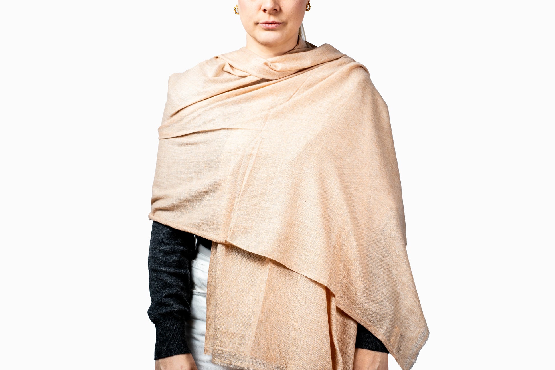 Person wearing a soft peach shawl pashmina on a white background