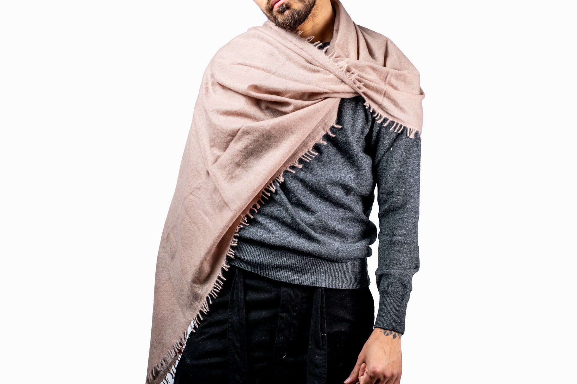 Man wearing a large soft brown cashmere scarf draped over his shoulders against a white background