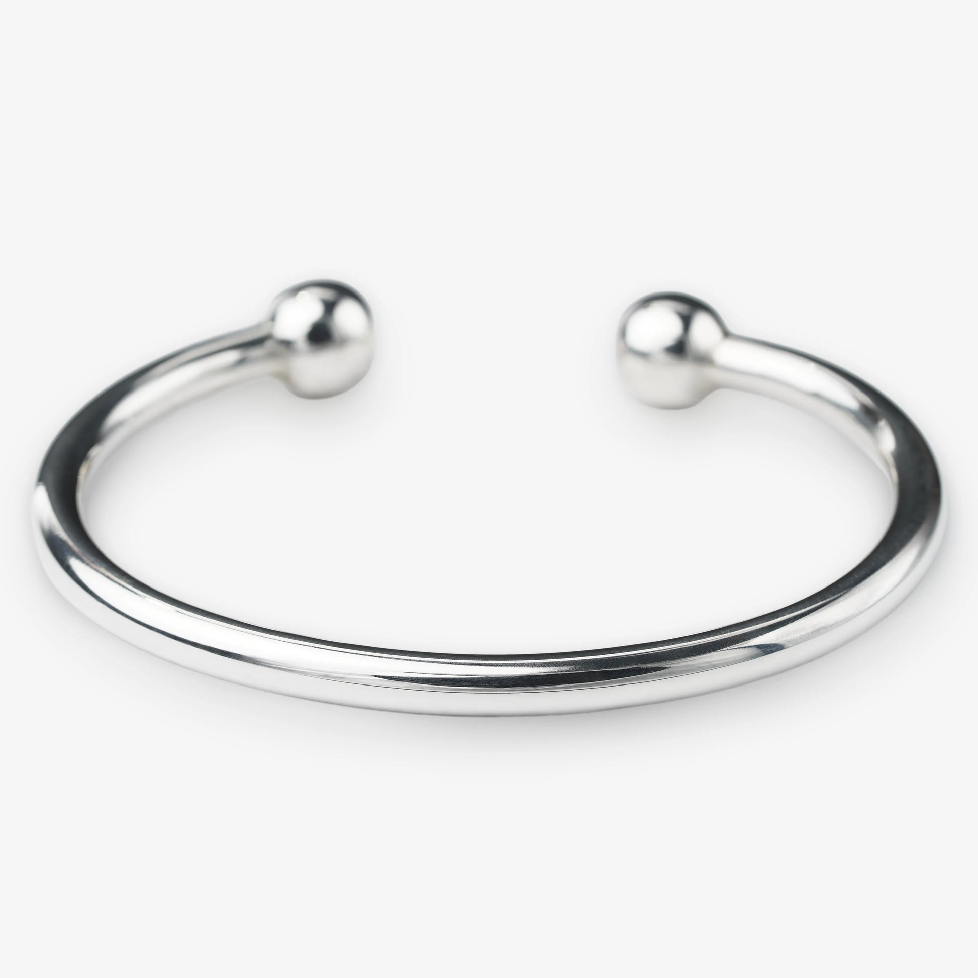 Silver bangle with spherical ends on a white background