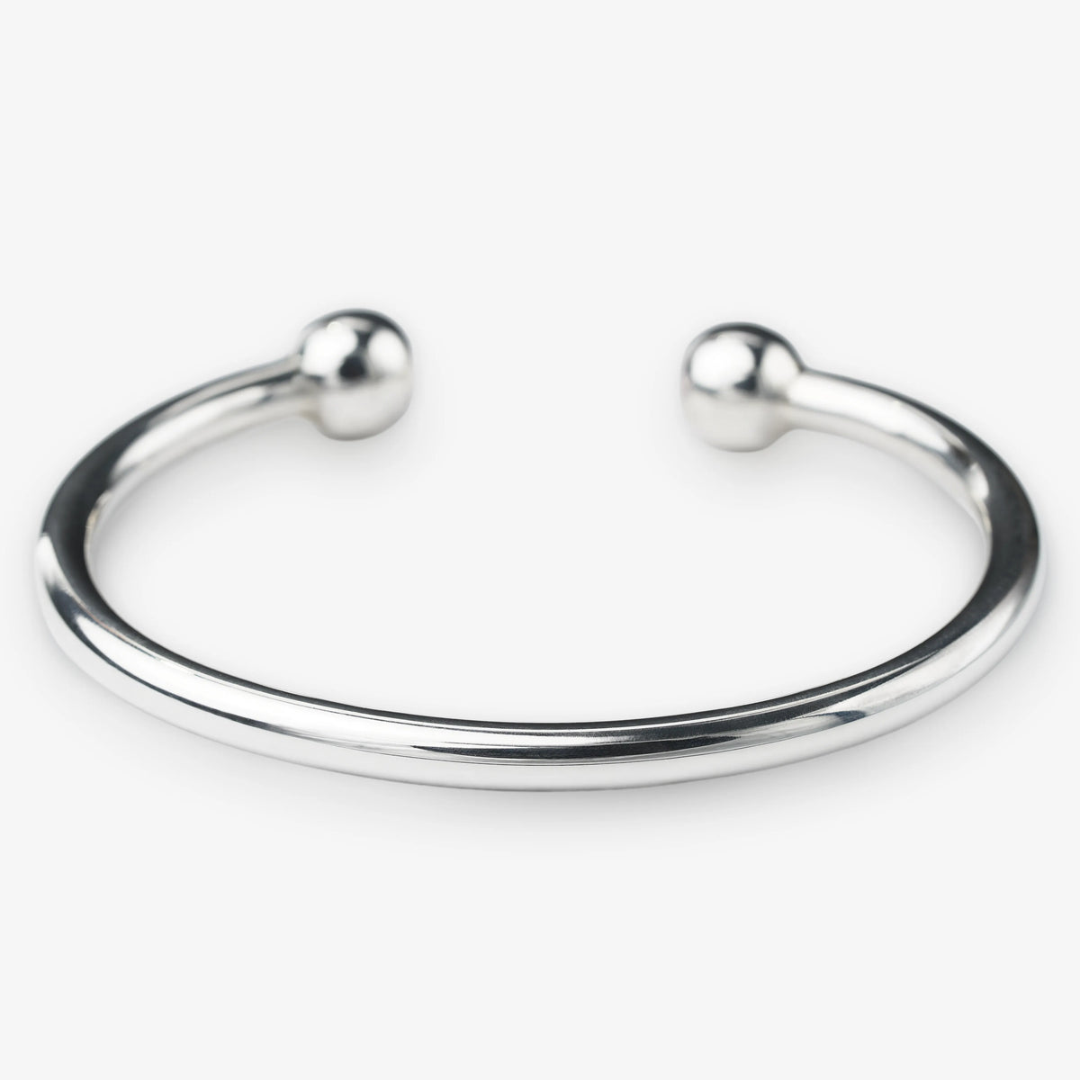 Silver bangle with spherical ends on a white background