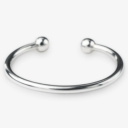Silver bangle with spherical ends on a white background