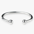 Silver bangle with two spherical beads on a white background