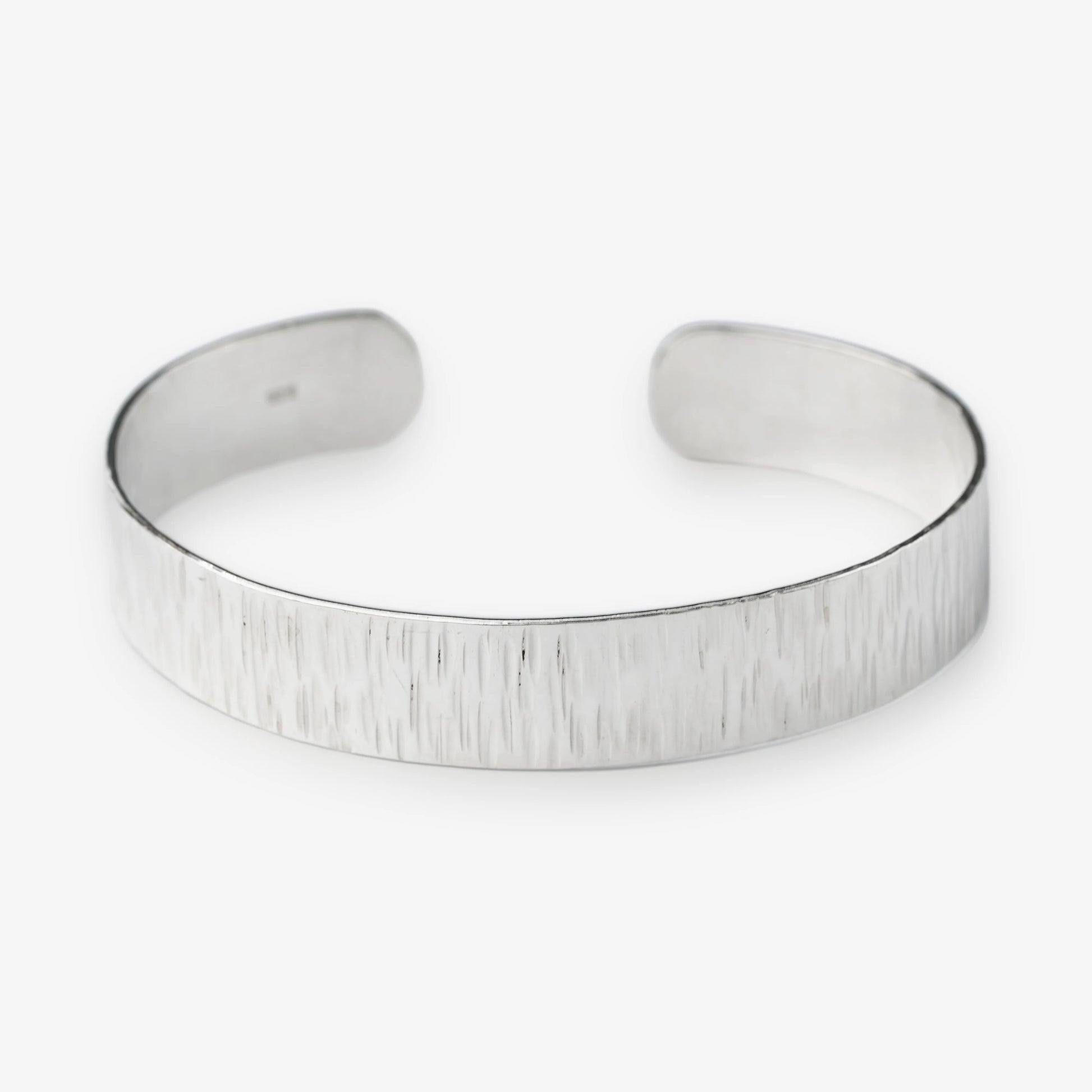 Sterling Silver cuff bracelet on a white background with brushed texture