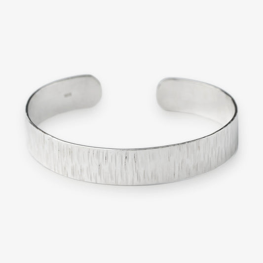 Sterling Silver cuff bracelet on a white background with brushed texture