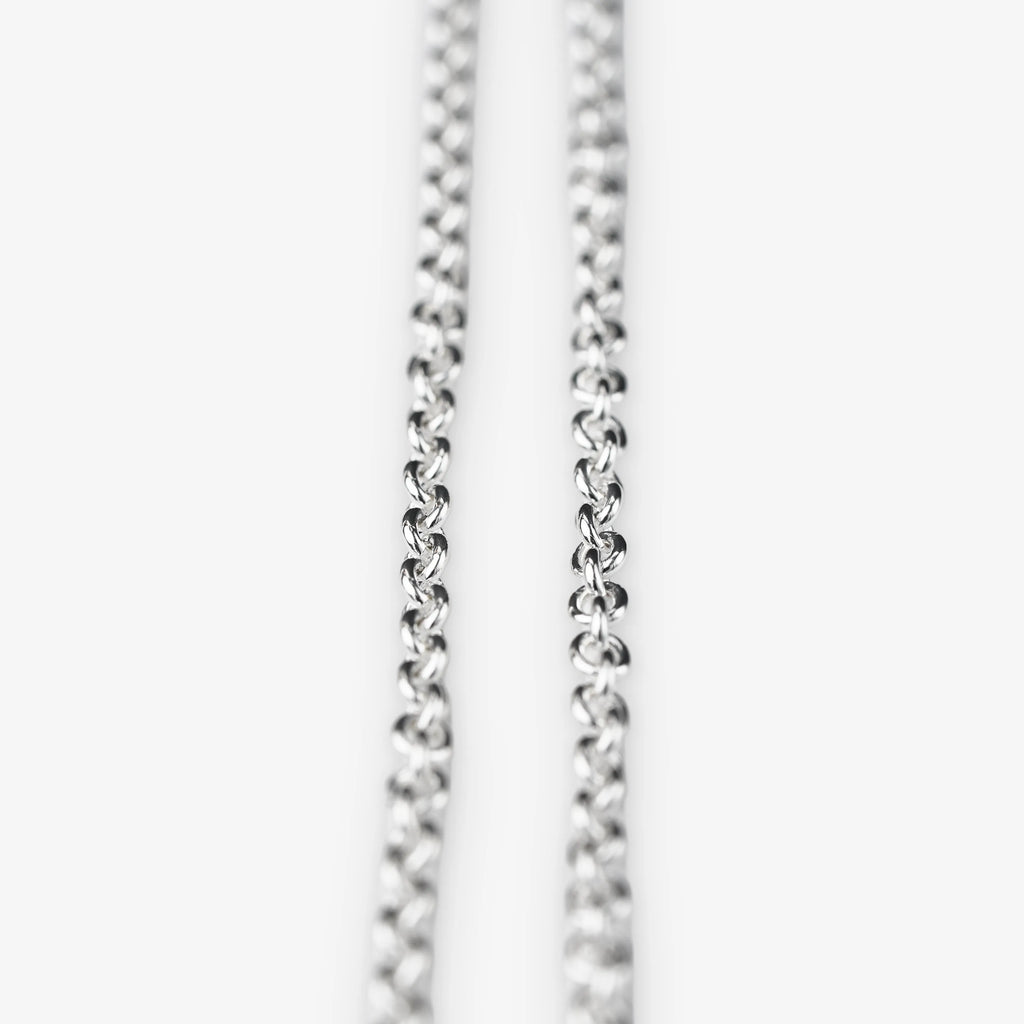 A close-up of a sterling silver belcher chain necklace against a plain white background.
