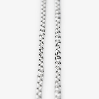 A close-up of a sterling silver belcher chain necklace against a plain white background.
