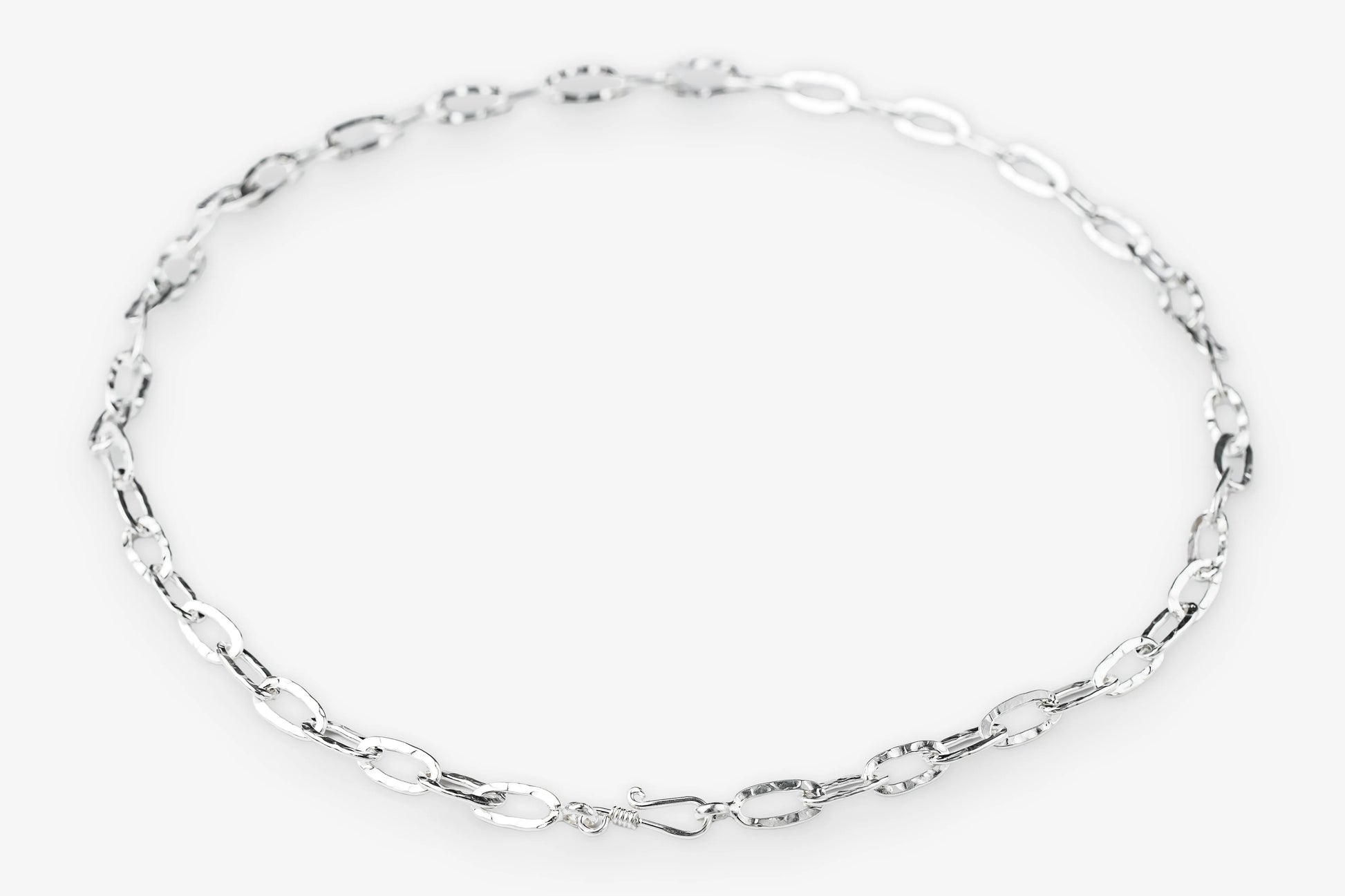 Silver paperclip chain necklace on a white background