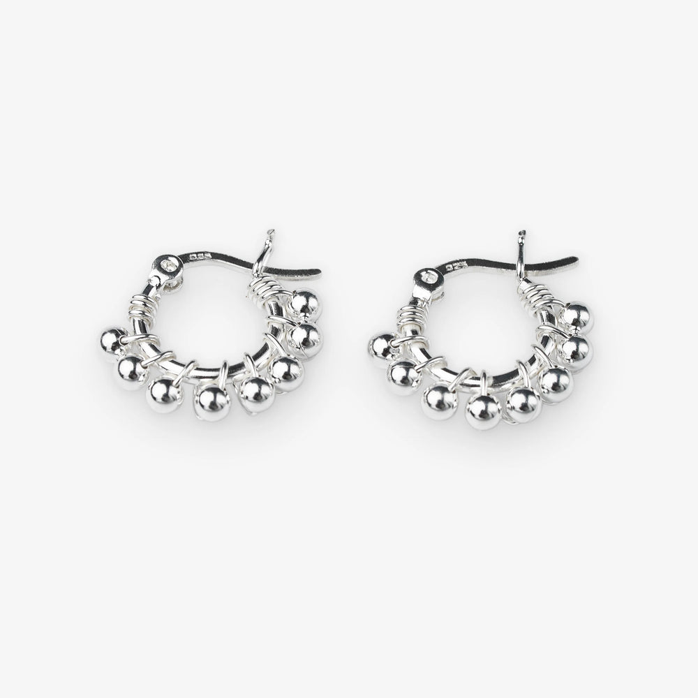 A pair of silver hoop earrings with dangling beaded fringe and a textured wire design, shown on a light gray background.