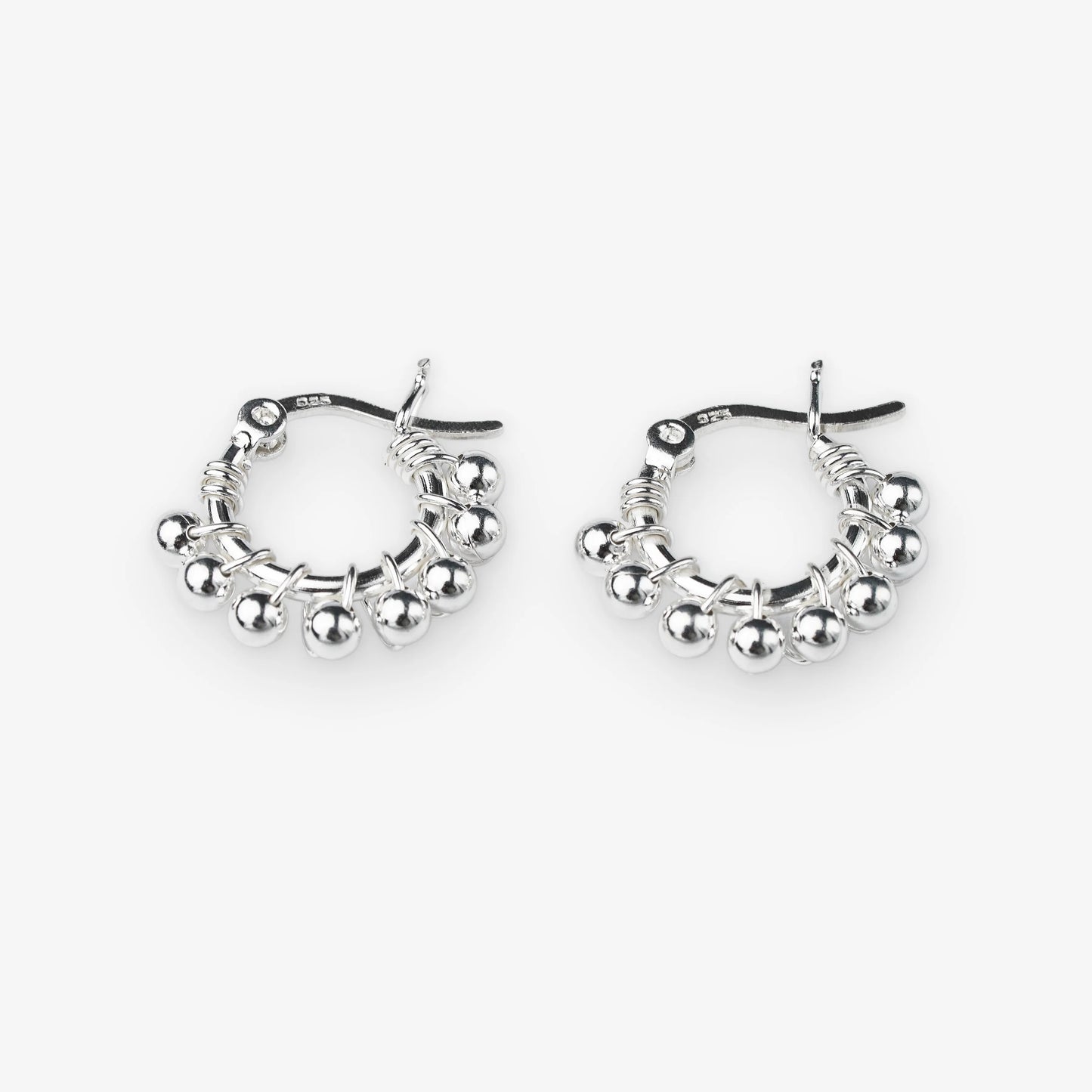 A pair of silver hoop earrings with dangling beaded fringe and a textured wire design, shown on a light gray background.