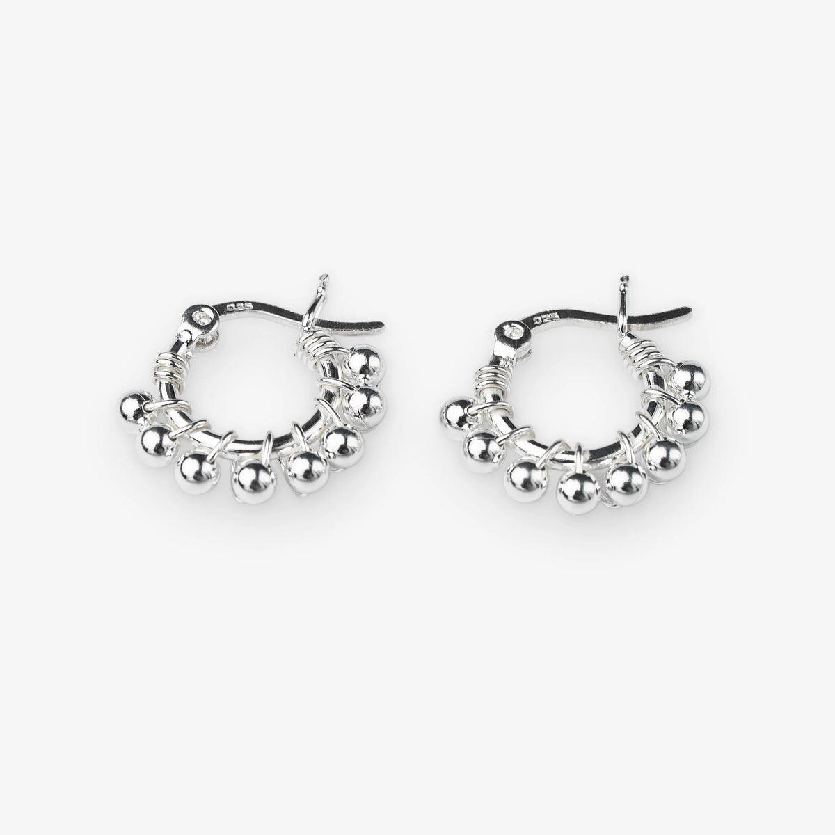 A pair of silver hoop earrings with dangling beaded fringe and a textured wire design, shown on a light gray background.