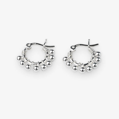 A pair of silver hoop earrings with dangling beaded fringe and a textured wire design, shown on a light gray background.