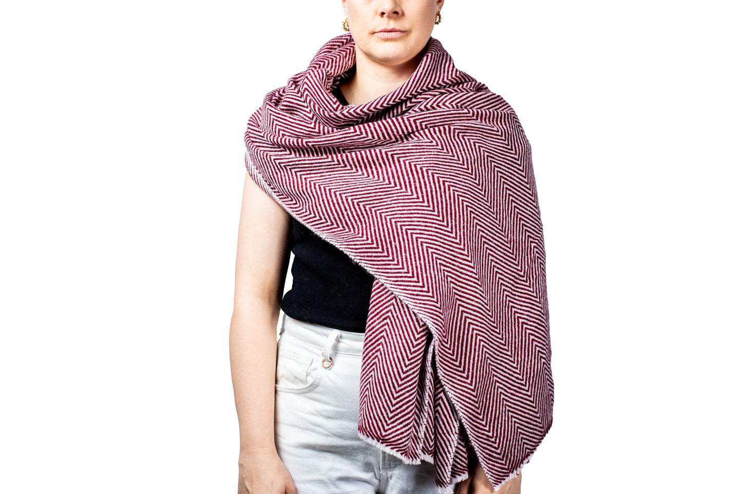 Person wearing a red and white patterned scarf pashina on a white background