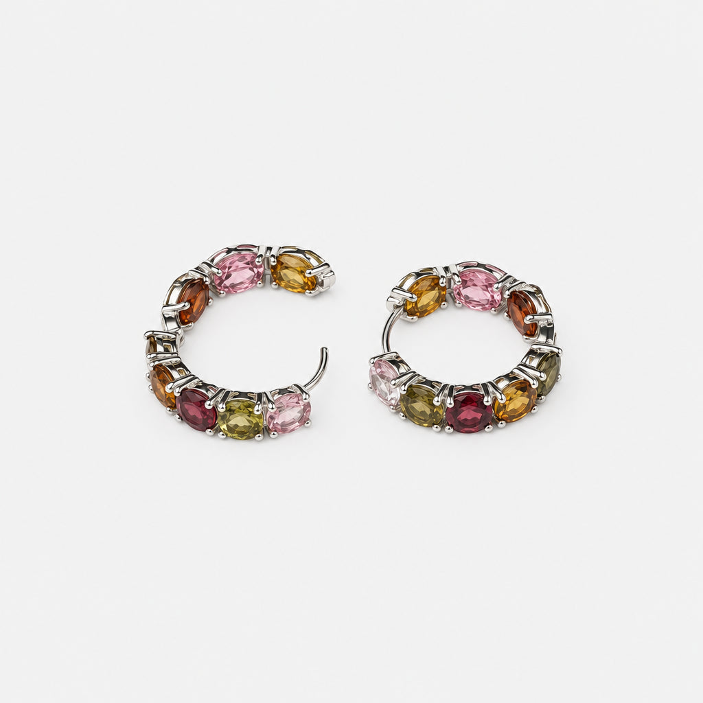 A pair of small silver-toned hoop earrings with multiple small round gemstones in pink, yellow, green, and burgundy, photographed on a plain white background.